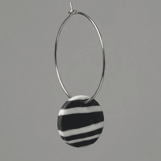 Close-up of striped disc hoop earrings made from polymer clay, showing the stripe pattern, texture, and stainless steel hardware.