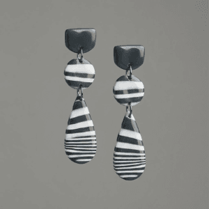 Pair of striped teardrop dangle earrings made from polymer clay, photographed together to show the matching pattern and shape.