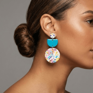 Close-up of Fig Thing handmade polymer clay statement earrings with layered design and stainless steel findings.