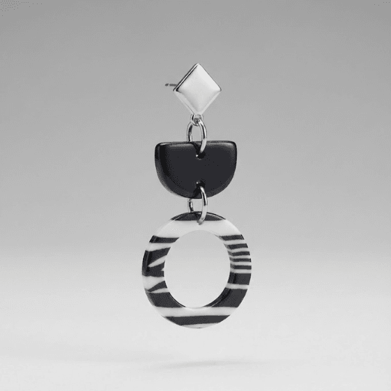 Close-up of zebra ring dangle earrings made from polymer clay, showing the zebra pattern and stainless steel hardware.
