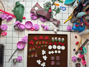 Handmade DIY Christmas earrings in red, white, green, and gold displayed on cards, ready for a Christmas market.