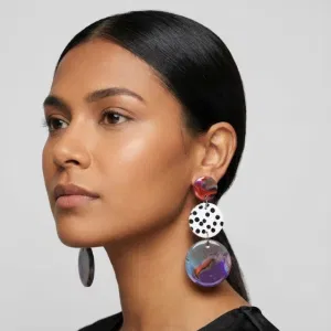 Model trägt marmorierte Statement-Ohrringe mit roter Scheibe oben, weiß-schwarz gepunkteter Scheibe in der Mitte und marmoriertem Anhänger in Lila-Blau.