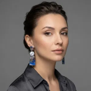 Model trägt handgemachte Ohrringe mit marmorierter oberer Scheibe, weißer Scheibe mit schwarzen Polka Dots in der Mitte und glänzend marmorierter unterer Scheibe in Violett-Blau.