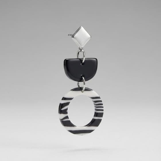 Nahaufnahme der Zebra-Ring-Hängeohrringe aus Polymer-Ton mit Zebramuster und Edelstahl-Steckern.